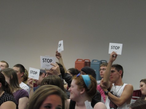Audience members hold up "STOP" signs at a performance of "Sex Signals"