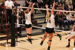 Players Penny Gwynn and Brooke Bell go up for a block against Whitworth College
