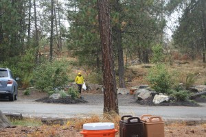 A volunteer returns with a garbage bag after cleaning trash from the trails and climbing spots of Q'emiln Park in Post Falls, Idaho.
